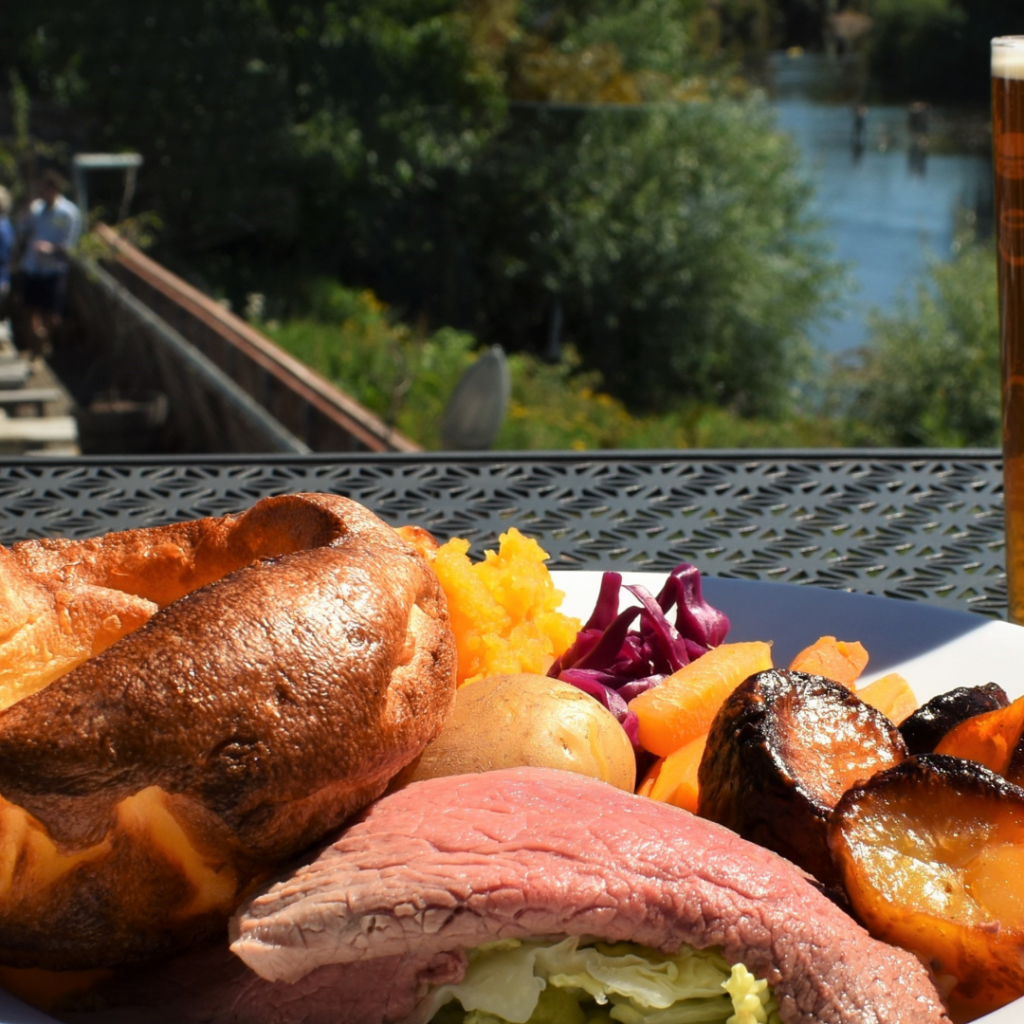 Roast beef dinner on a plate with a river inthe background