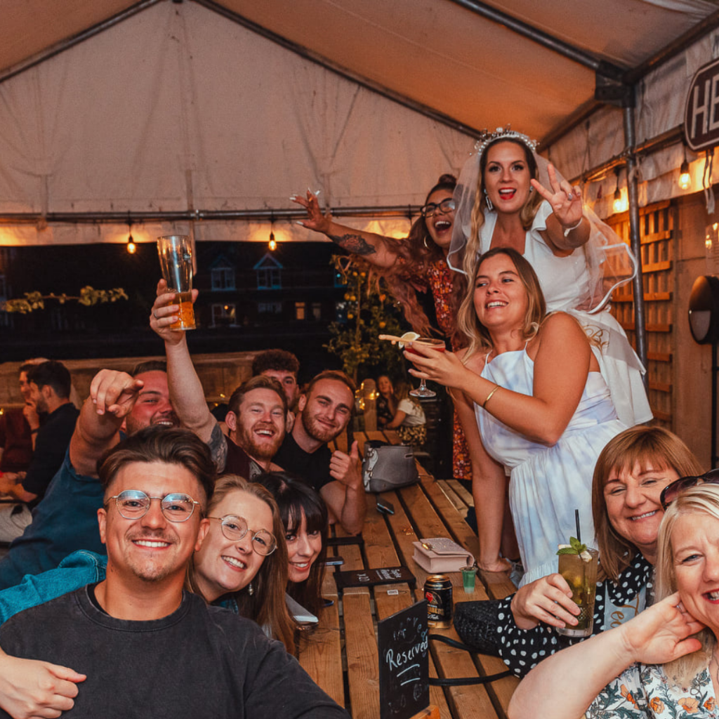 group of people enjoying a hen night outside under a marquee
